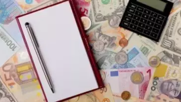 calculator and notepad on money background