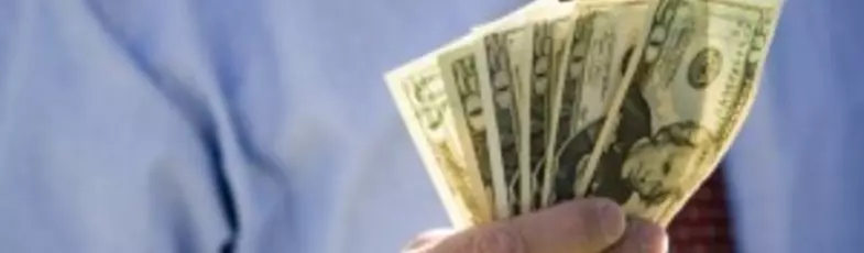 Midsection of a businessman holding American dollars